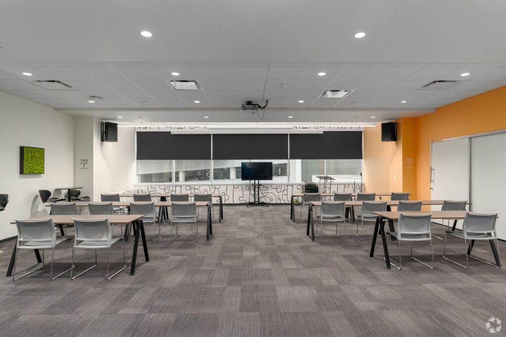 A CIC event space with tables and chairs in classroom setup and a TV monitor at the front of the room.