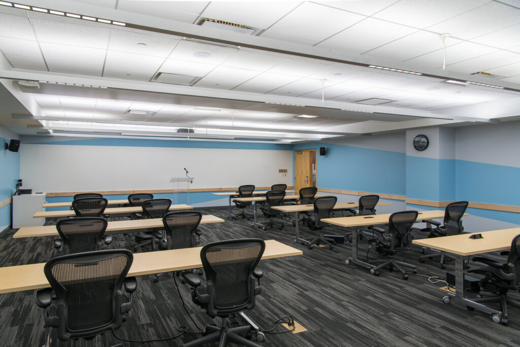 Havana hybrid event space with tables and chairs in classroom style and whiteboard wall