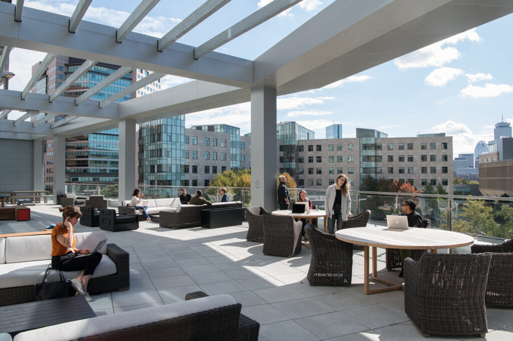 Outdoor patio at CIC with mixed seating and view of Kendall Square