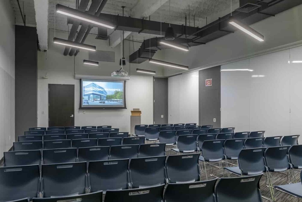 Scarborough event space with chairs in lecture style and podium and projector screen at the front of the room