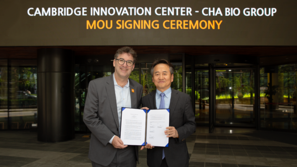 CIC Founder & CEO, Tim Rowe, and CHA Biotech, Justin Oh stand together with signed MOU to celebrate the agreement.