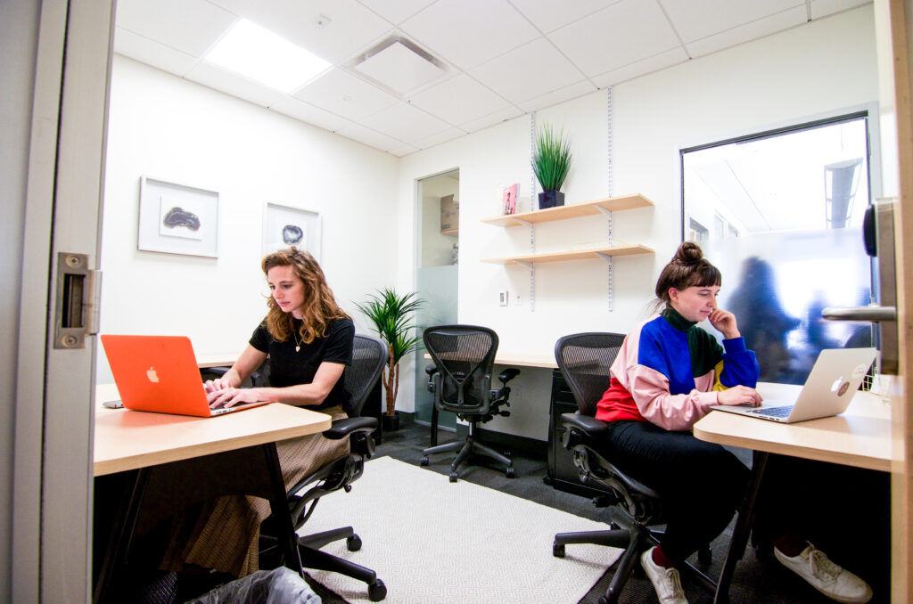 Two people working at dedicated desks