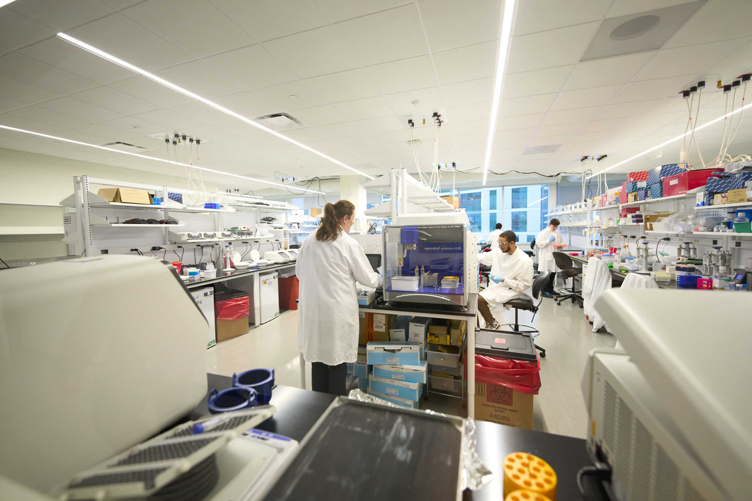 Man in a lab coat smiling while working in a CIC shared lab space