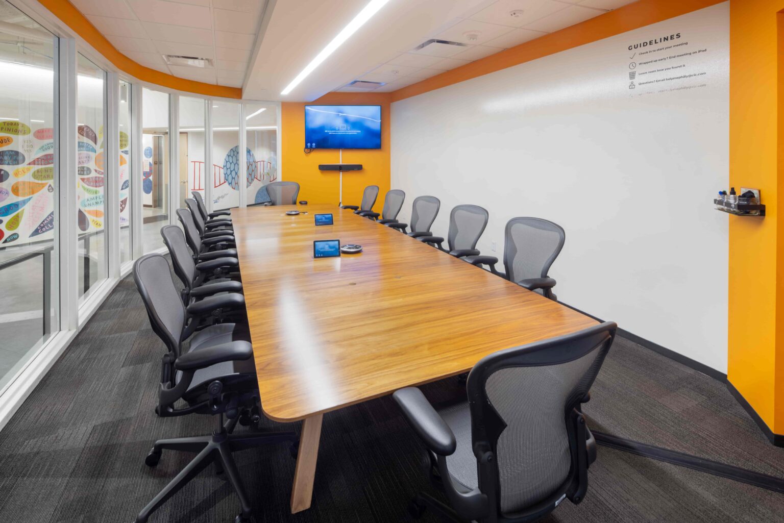 Large conference room with boardroom table, video conferencing, and whiteboard wall