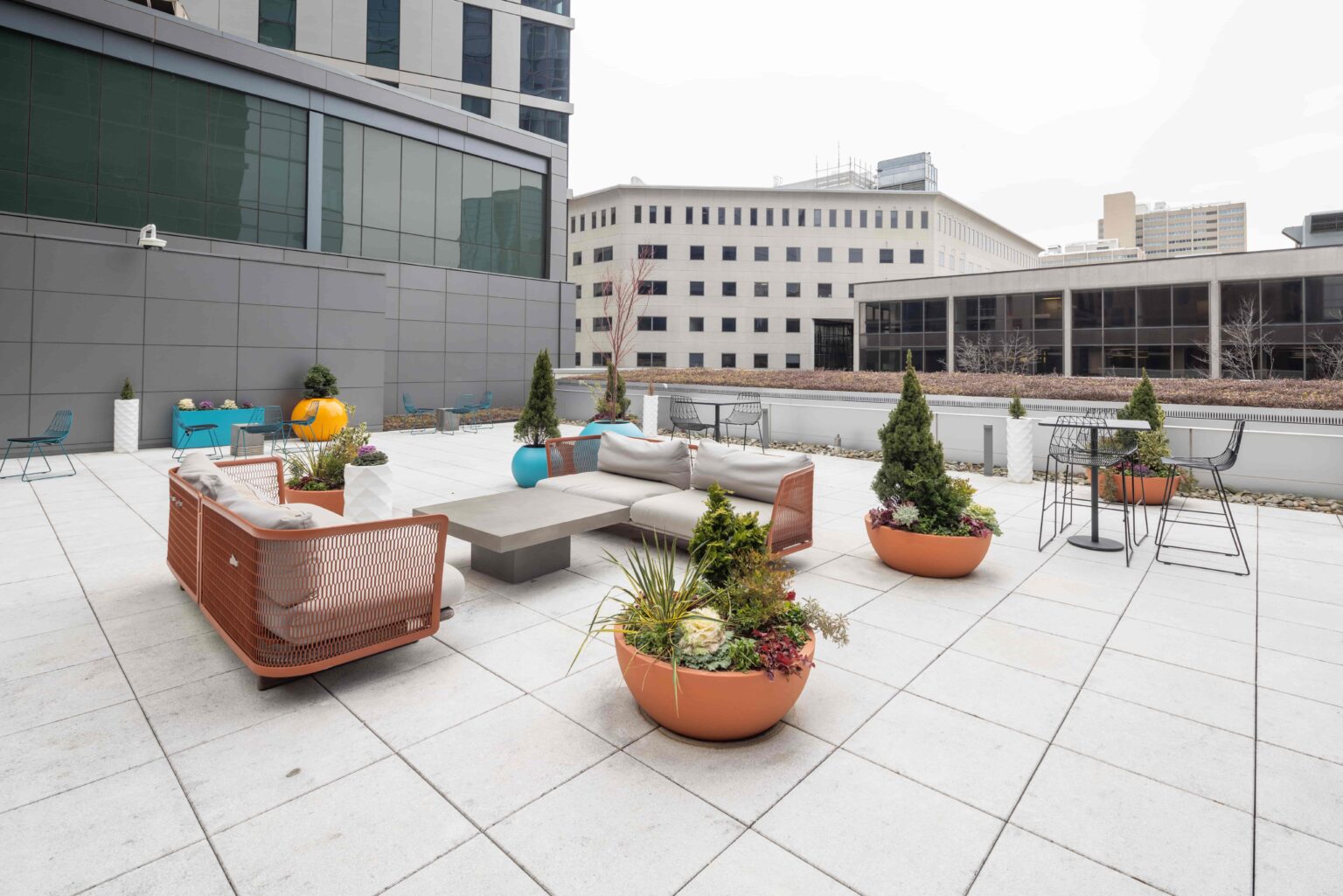 A spacious terrace area featuring sofas, tables, chairs, and a view