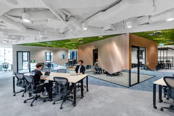 Two people working at shared desks in CIC Warsaw's coworking space