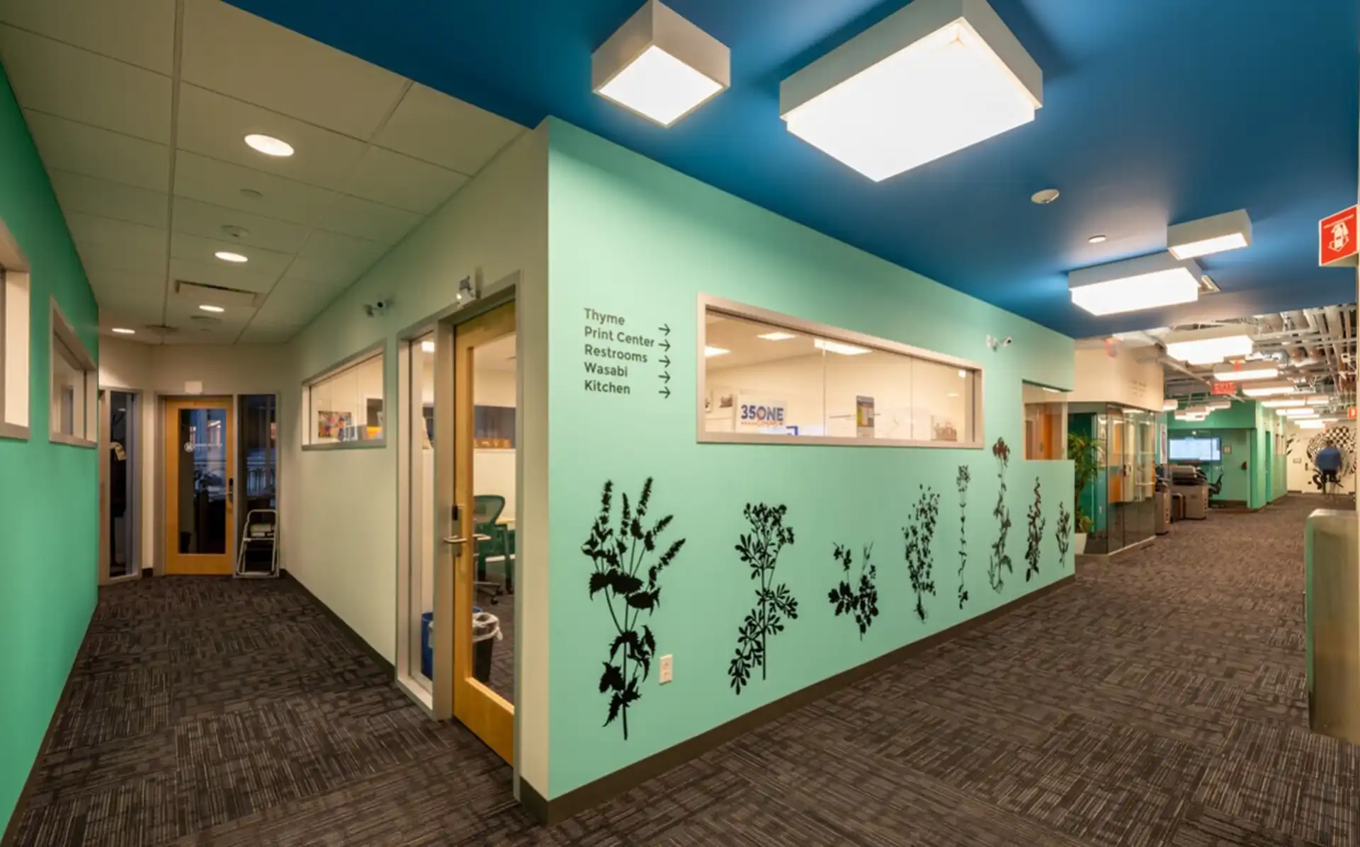 Hallway with green wall and plant decals at CIC Boston