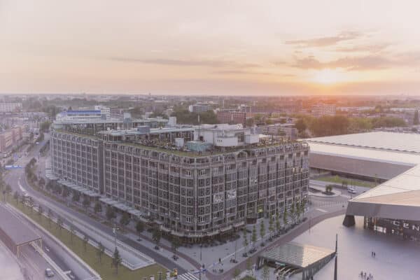The exterior of the CIC Rotterdam building with the sunrise in the background.